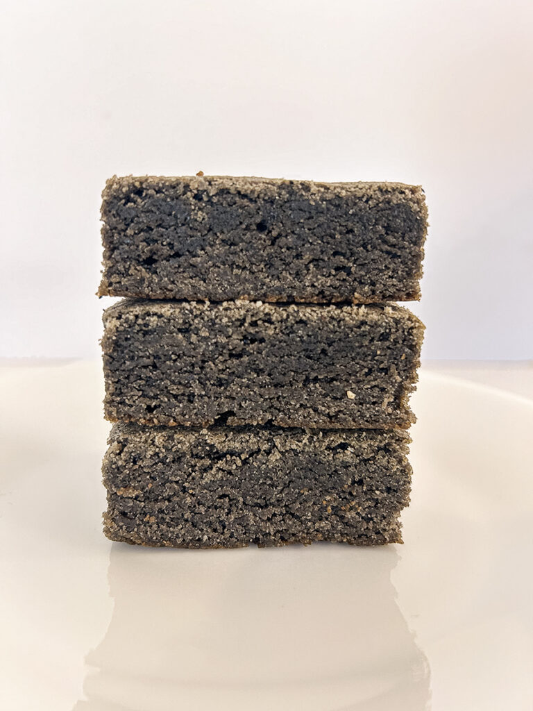 cross section of 3 stacked square black sesame blondie